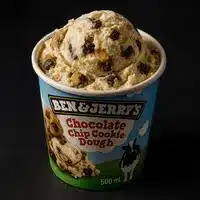 Pinte de crème glacée Ben & Jerry's saveur Chocolate Chip Cookie Dough, débordante de pâte à biscuits et pépites de chocolat.