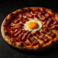 Pizza artisanale garnie de tranches de bacon croustillantes et d'un œuf au plat central, reposant sur une surface sombre.