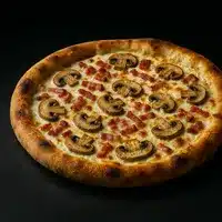 Pizza croustillante garnie de champignons tranchés et de morceaux de bacon sur une base crémeuse, mettant en valeur la croûte dorée.