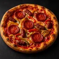 Pizza croustillante garnie de tranches de pepperoni, saucisses épicées, et poivrons jaunes et rouges, posée sur une surface sombre.