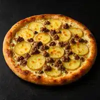 Pizza gourmande avec fines tranches de pomme de terre dorées et morceaux de viande hachée brune sur une croûte cuite.