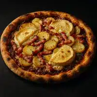 Pizza gourmande aux pommes de terre, lardons et morceaux de reblochon fondus, sur une croûte bien dorée.